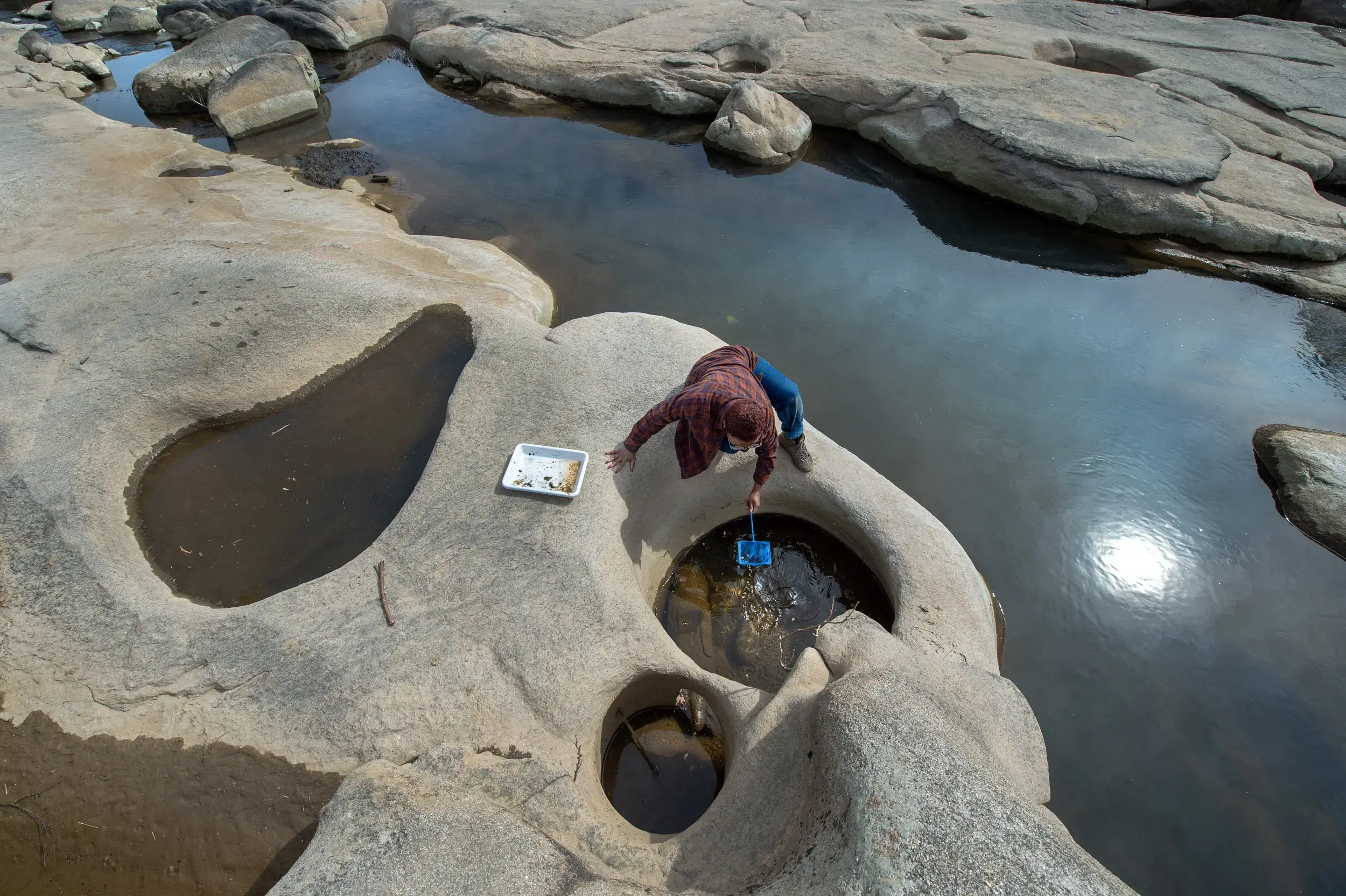 Jennoa Fleming, a senior environmental studies major at VCU, researches the James River rock pools, focusing on a small aquatic snail.