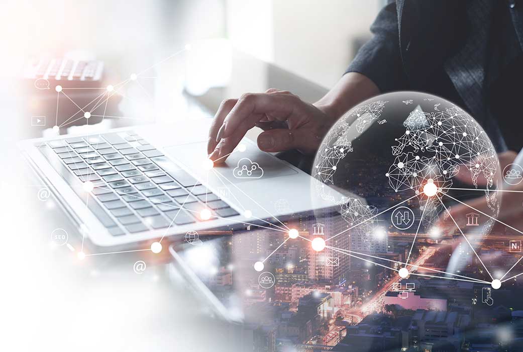 Hand on laptop and world image on the side