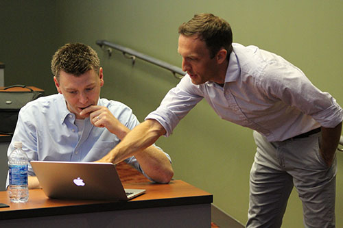 2 men looking at the laptop