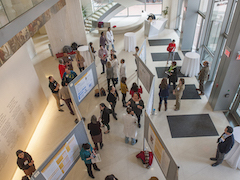 Birdeye view of a crowd of people looking at poster displays